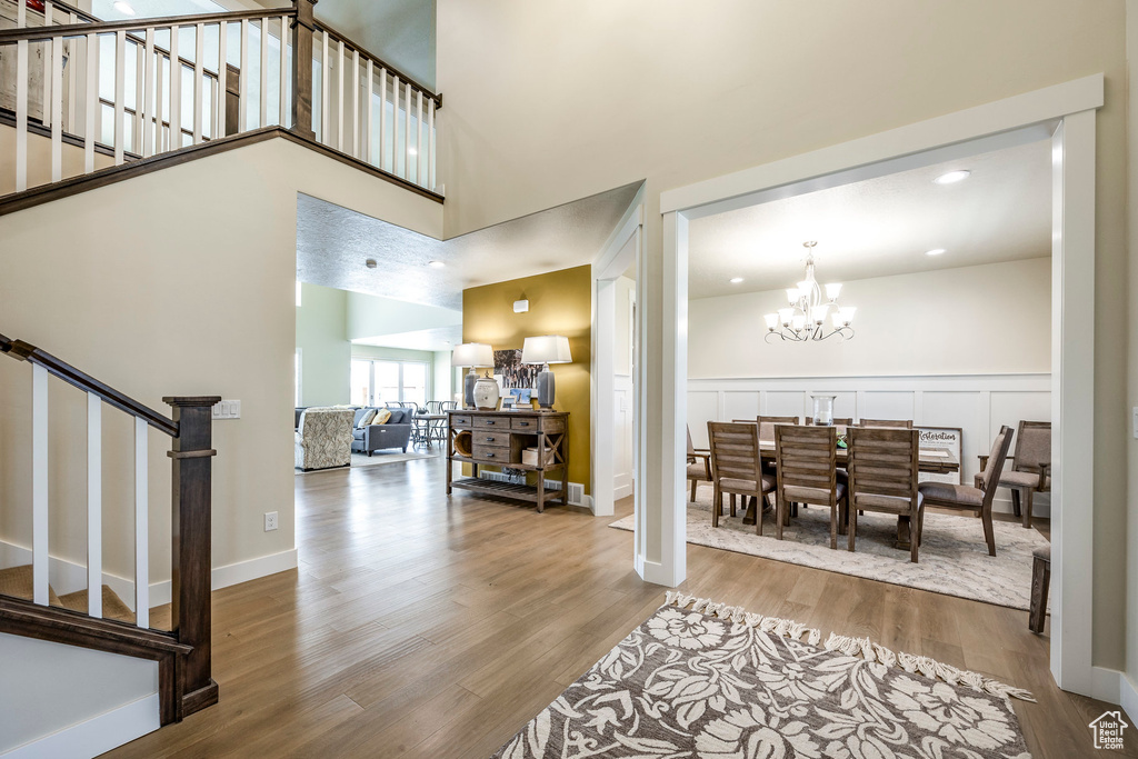 Entryway with a notable chandelier, hardwood / wood-style flooring, and a high ceiling