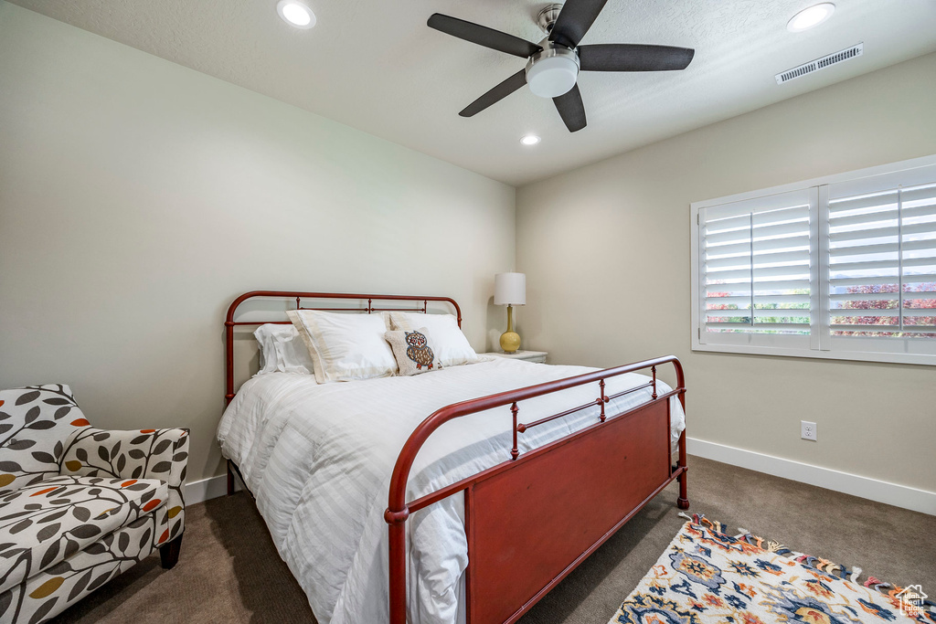 Bedroom with dark colored carpet and ceiling fan