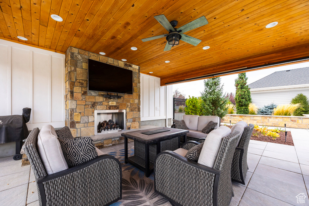 View of patio / terrace with ceiling fan and an outdoor living space with a fireplace