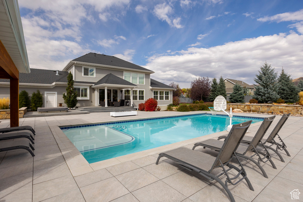 View of swimming pool with a water slide and a patio