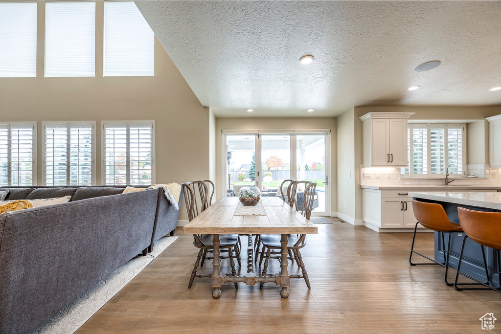 Dining room featuring a textured ceiling, plenty of natural light, and hardwood / wood-style floors