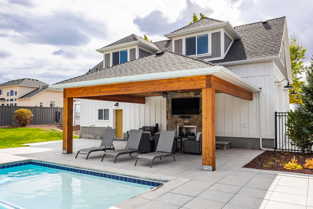 Back of property with a gazebo, a patio area, a fenced in pool, and ceiling fan