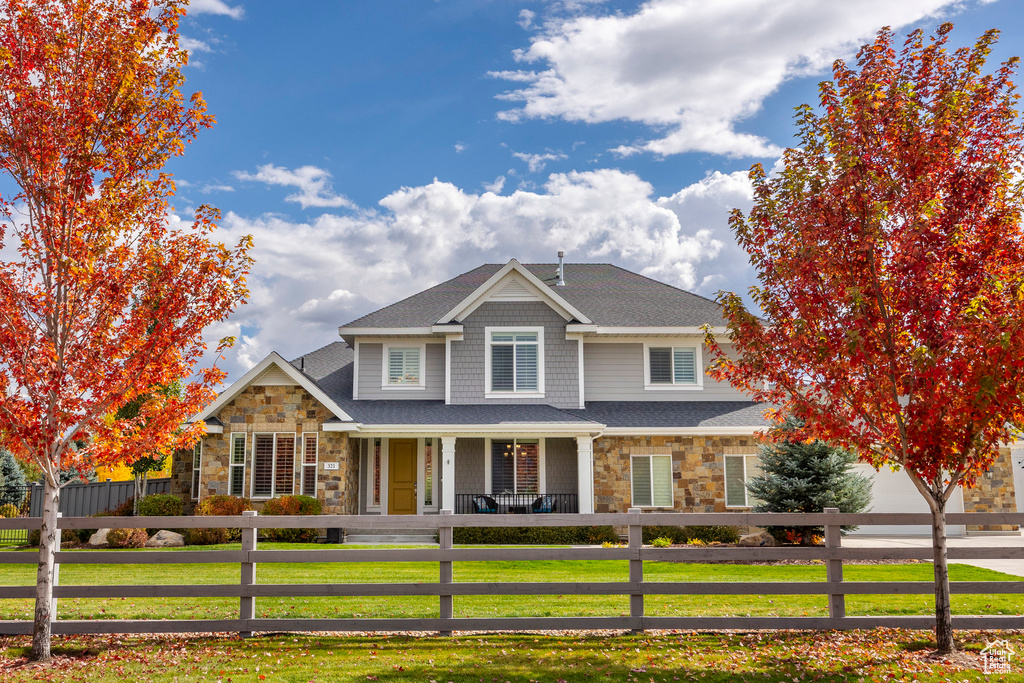 View of front of property with a front yard and covered porch