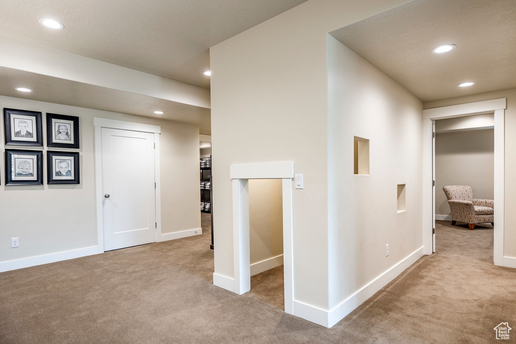 Corridor featuring light colored carpet