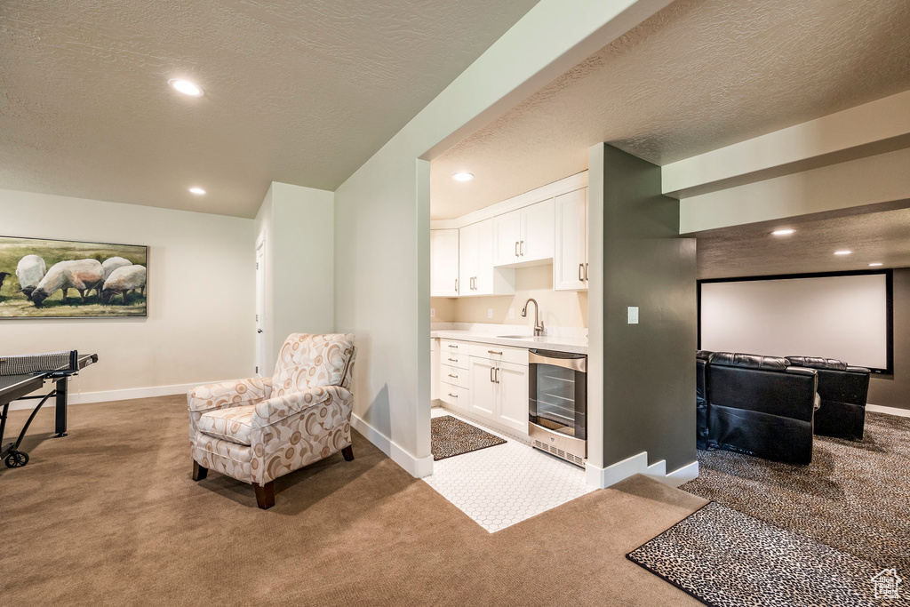 Interior space featuring wine cooler, a textured ceiling, and carpet floors