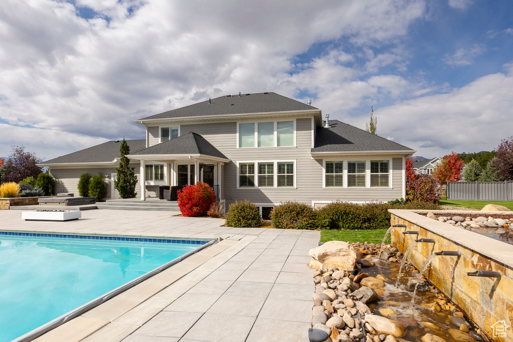 Rear view of property with a patio area and a fenced in pool