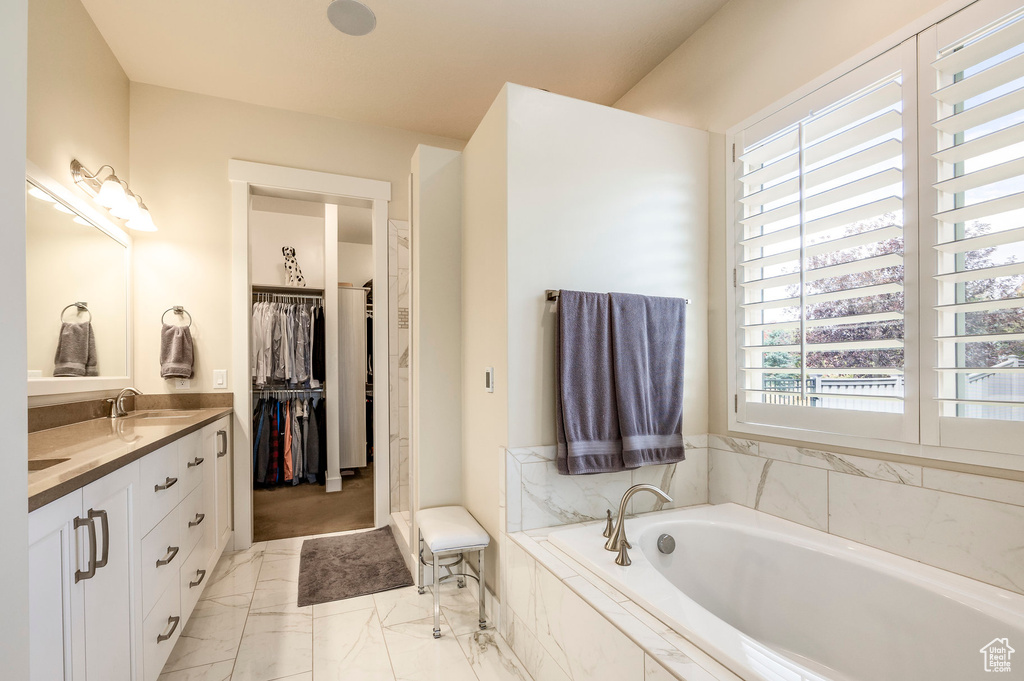 Bathroom with vanity and tiled tub