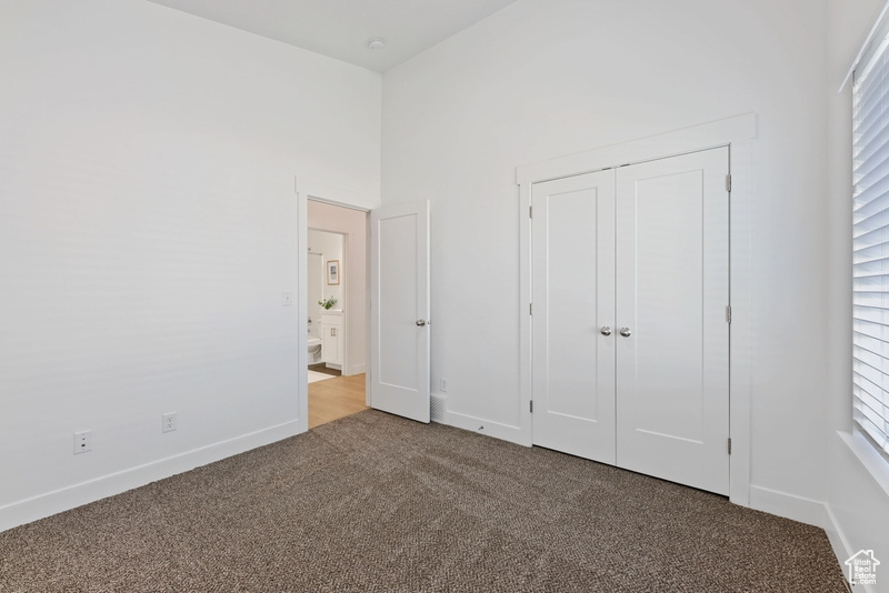 Unfurnished bedroom with a closet and carpet flooring