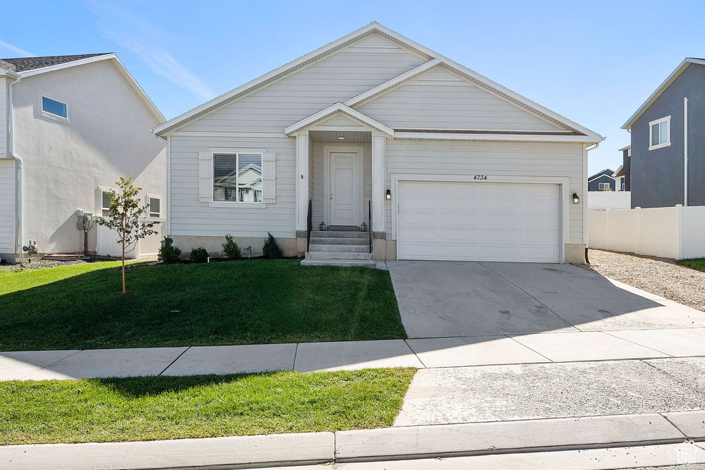 View of front facade with a garage and a front lawn