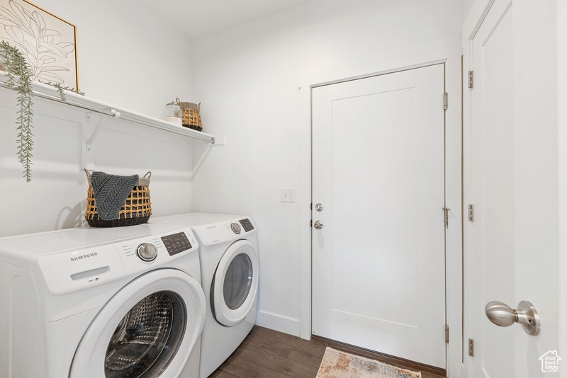 Laundry room featuring dark wood-type flooring and washer and dryer