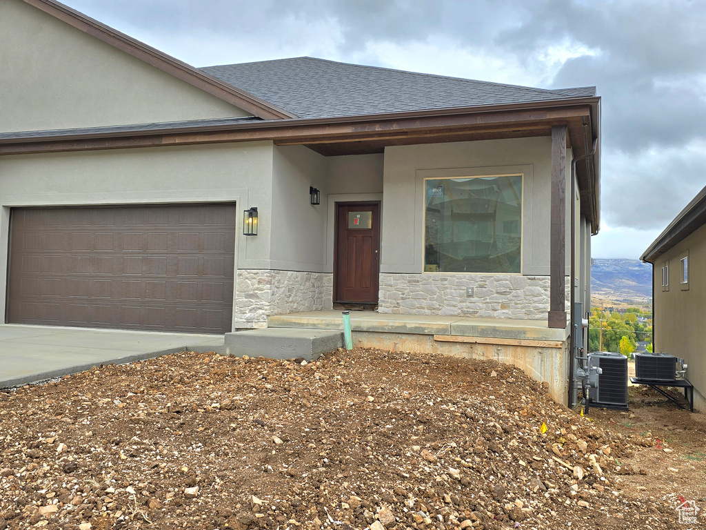 View of front of house with cooling unit and a garage