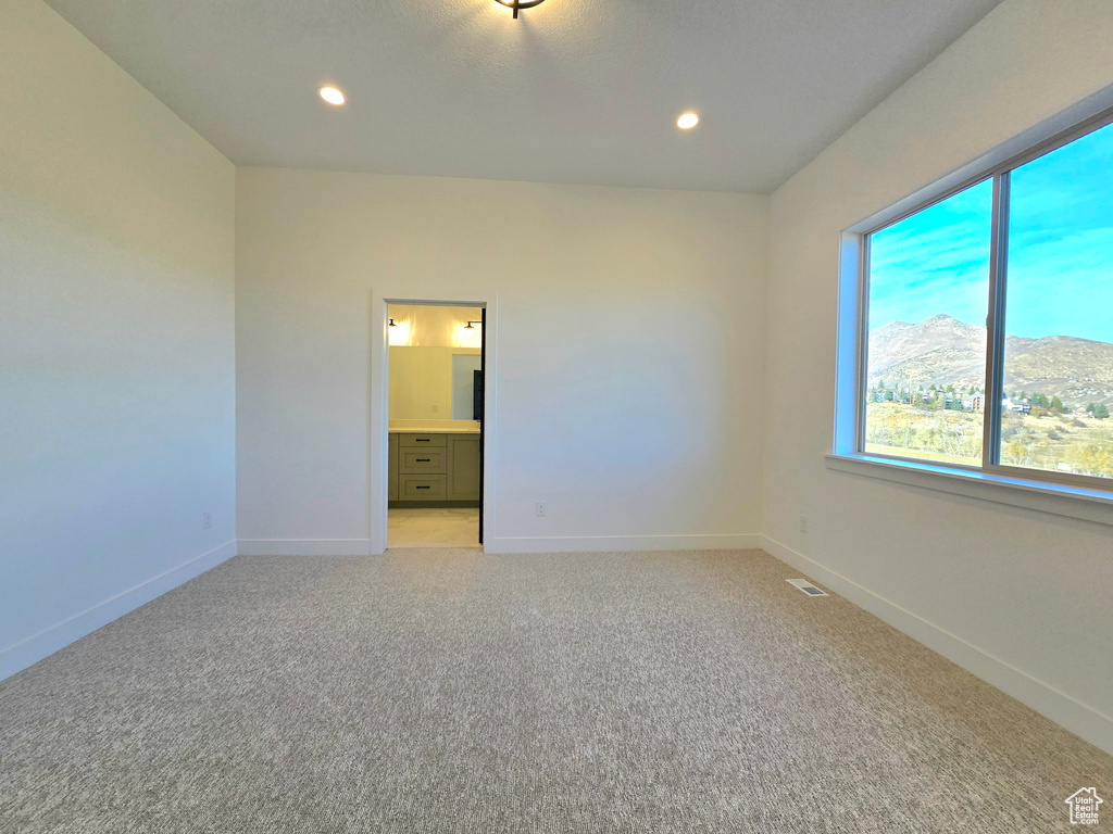 Carpeted empty room featuring a mountain view