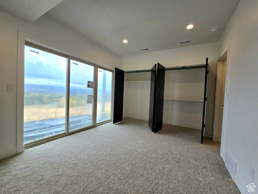 Unfurnished bedroom featuring carpet flooring and access to outside