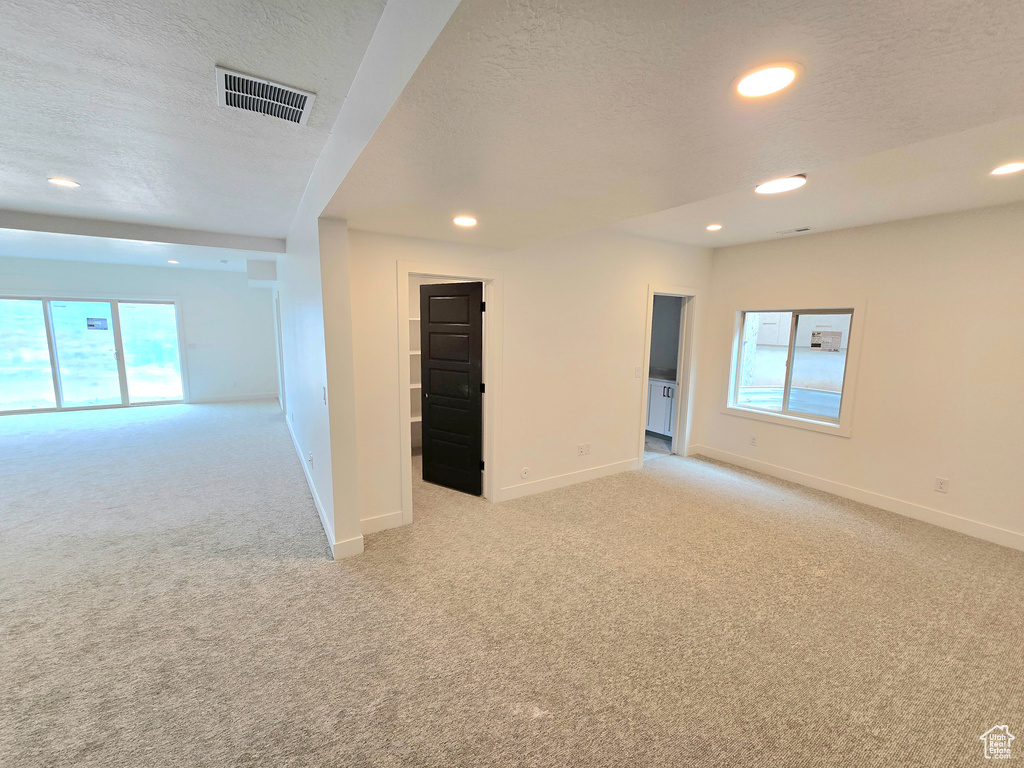 Carpeted spare room featuring a textured ceiling