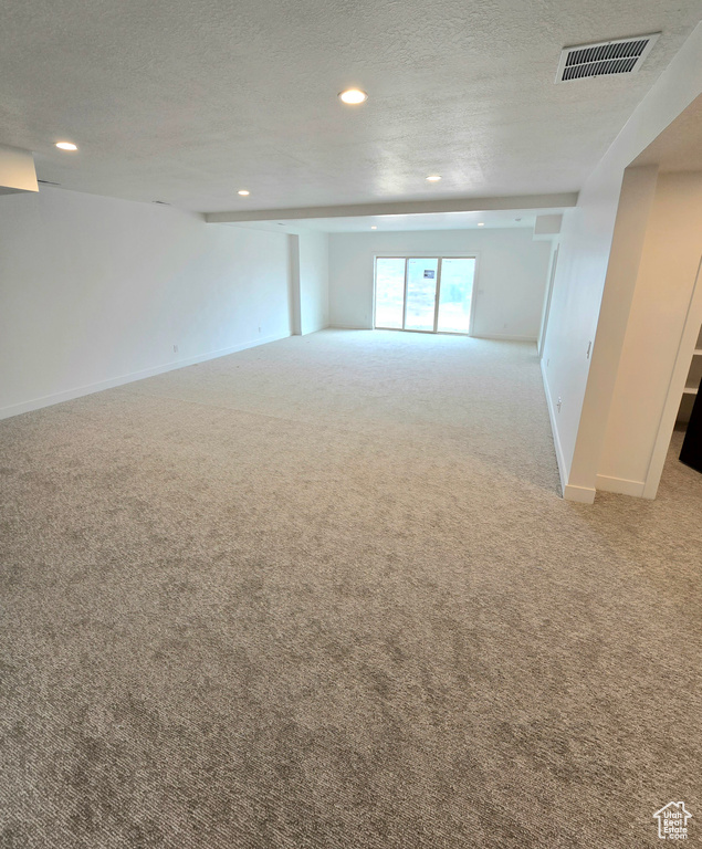 Carpeted empty room with a textured ceiling