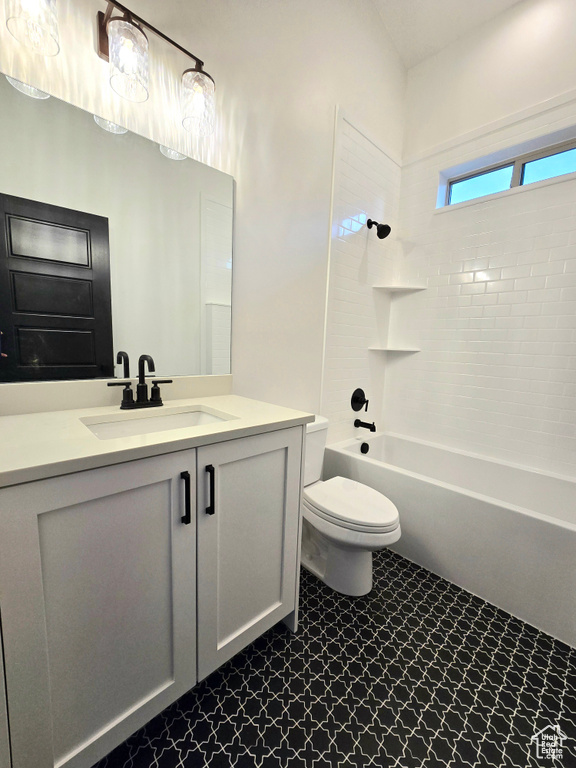 Full bathroom featuring toilet, vanity, and tiled shower / bath