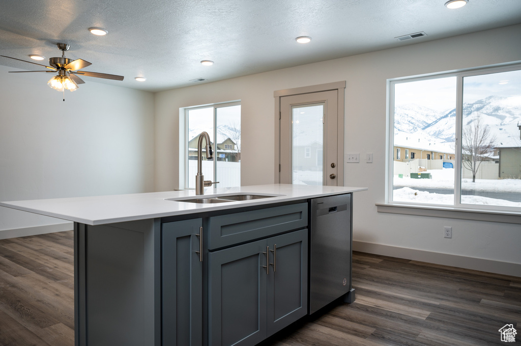 Kitchen featuring a center island with sink, dishwasher, dark wood-type flooring, gray cabinets, and sink