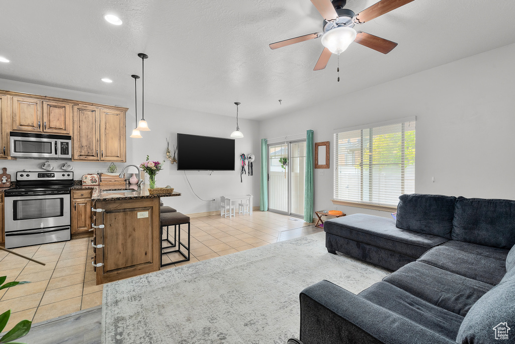 Tiled living room featuring sink and ceiling fan