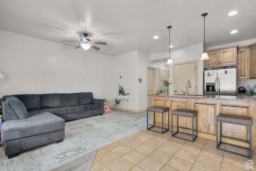 Living room featuring sink, ceiling fan, and light tile patterned floors