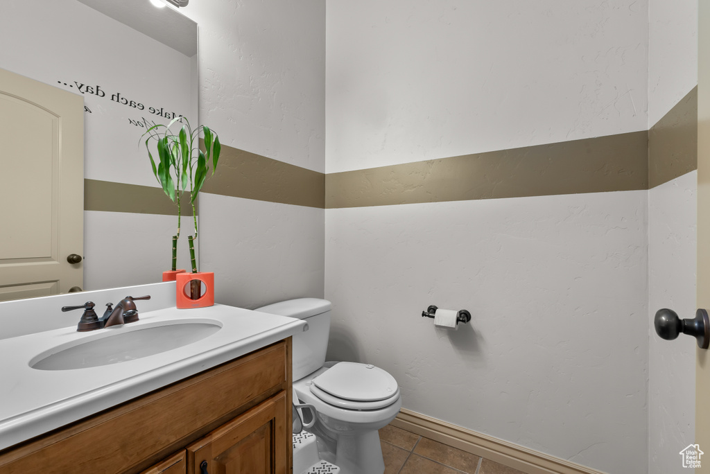 Bathroom featuring vanity, toilet, and tile patterned flooring