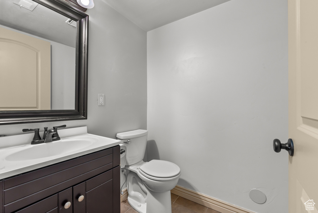 Bathroom featuring vanity, toilet, and tile patterned floors