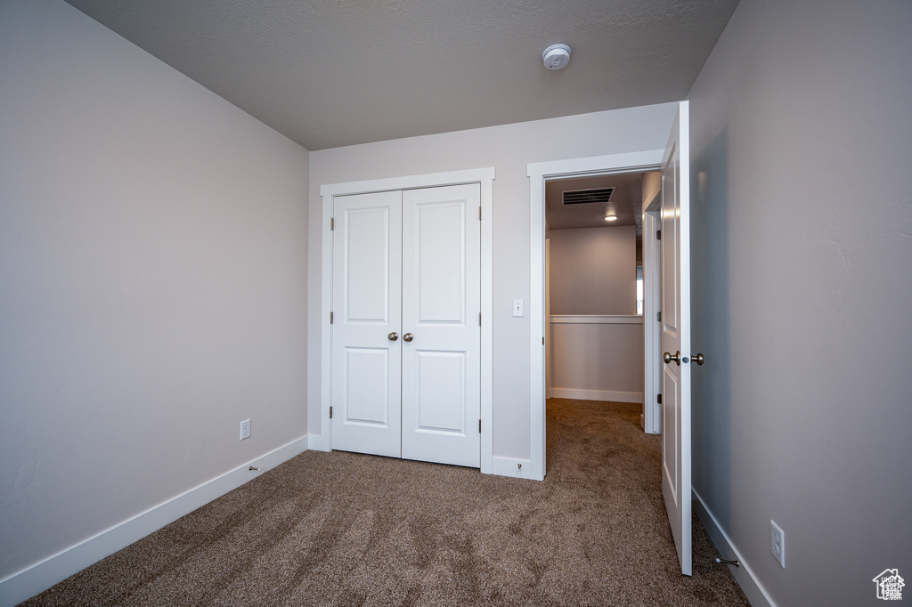 Unfurnished bedroom with a closet and carpet flooring