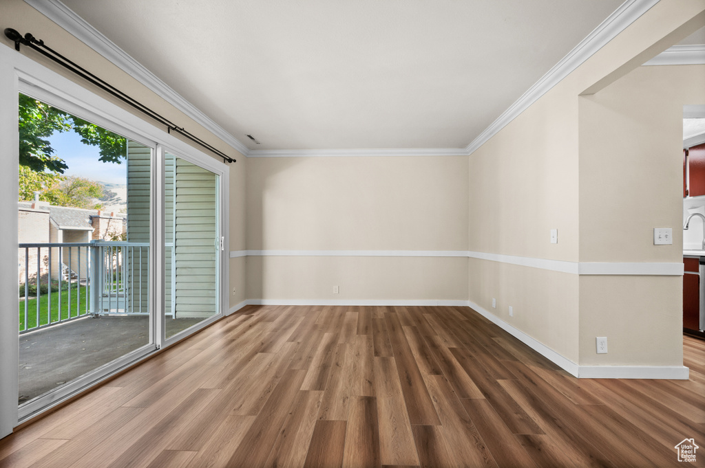 Spare room featuring crown molding and wood-type flooring