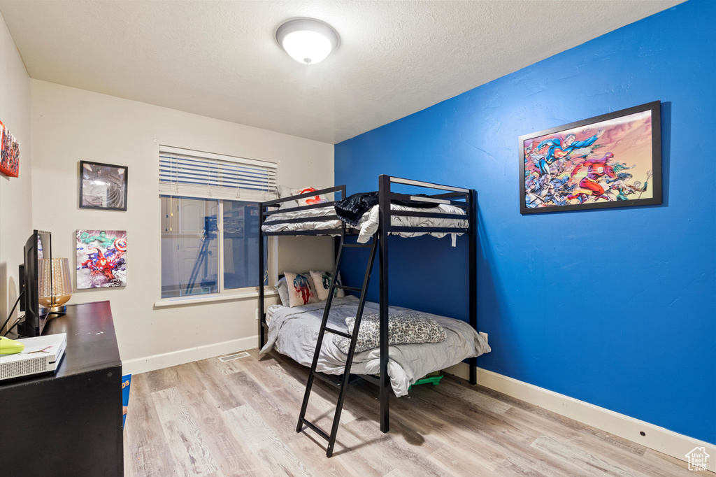 Bedroom featuring light hardwood / wood-style flooring and a textured ceiling