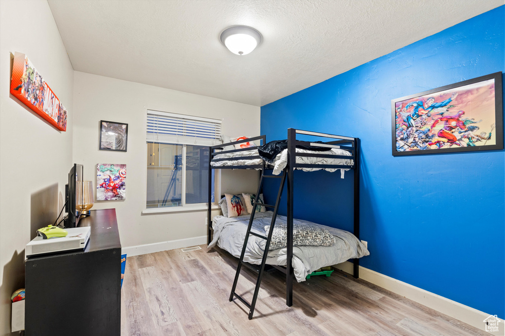 Bedroom with hardwood / wood-style floors and a textured ceiling