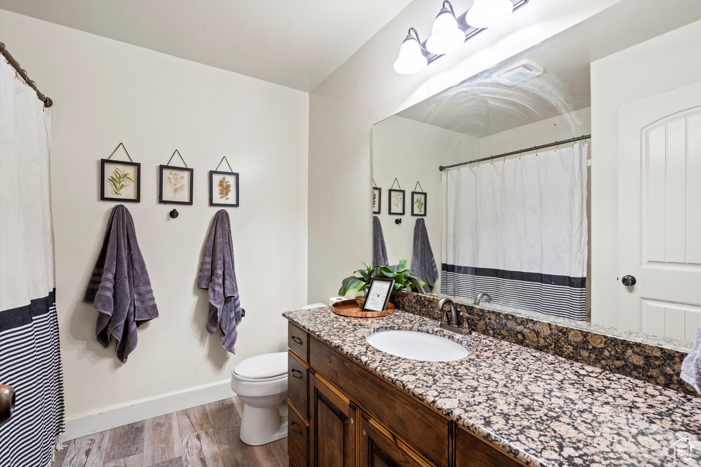 Bathroom featuring toilet, hardwood / wood-style flooring, and vanity