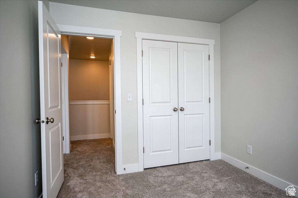 Unfurnished bedroom featuring a closet and light carpet