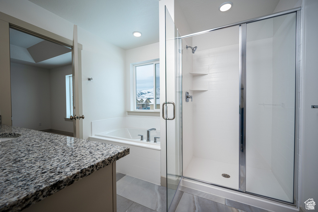 Bathroom featuring vanity, independent shower and bath, and tile patterned flooring