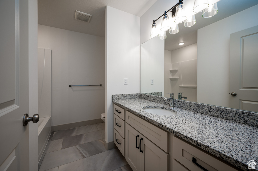 Bathroom featuring vanity, toilet, and tile patterned floors