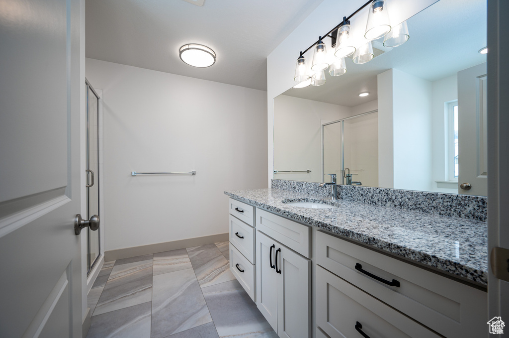 Bathroom with vanity and a shower with shower door