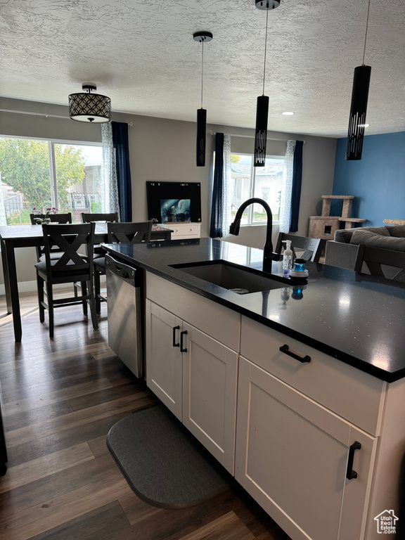 Kitchen with a wealth of natural light, sink, and decorative light fixtures