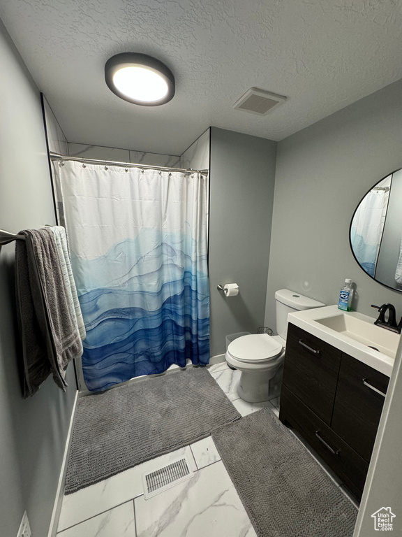 Bathroom featuring vanity, a shower with curtain, a textured ceiling, and toilet