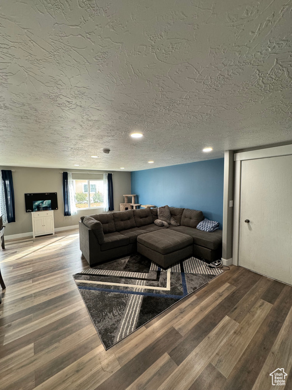 Living room with a textured ceiling and hardwood / wood-style floors