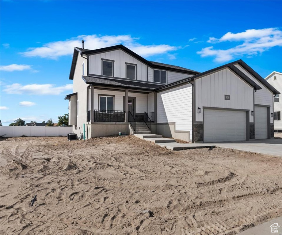 View of front of house with covered porch and a garage