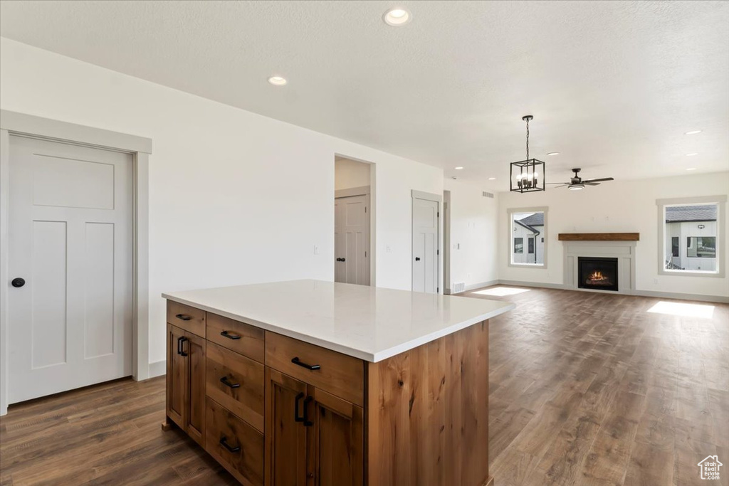 Kitchen featuring ceiling fan, dark hardwood / wood-style flooring, a kitchen island, and hanging light fixtures