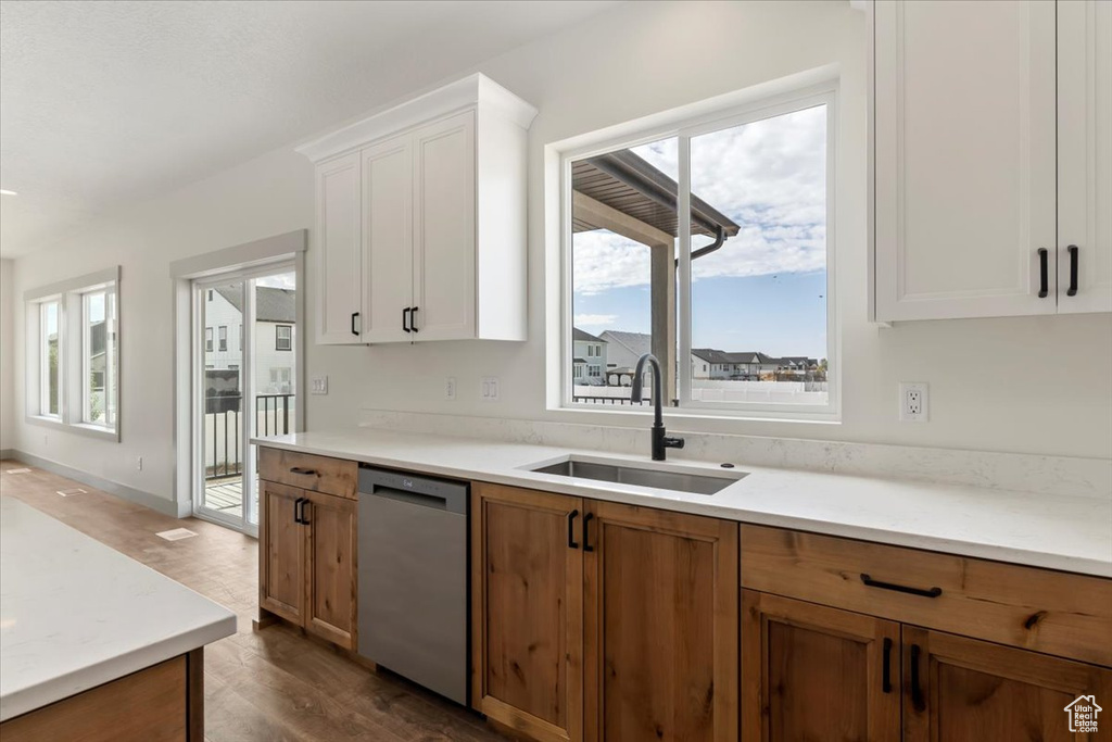 Kitchen featuring dishwasher, white cabinets, sink, and dark hardwood / wood-style flooring