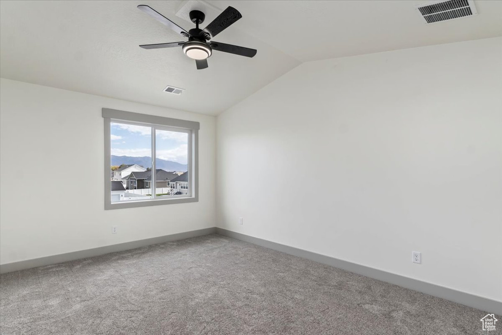 Unfurnished room with carpet floors, ceiling fan, and vaulted ceiling