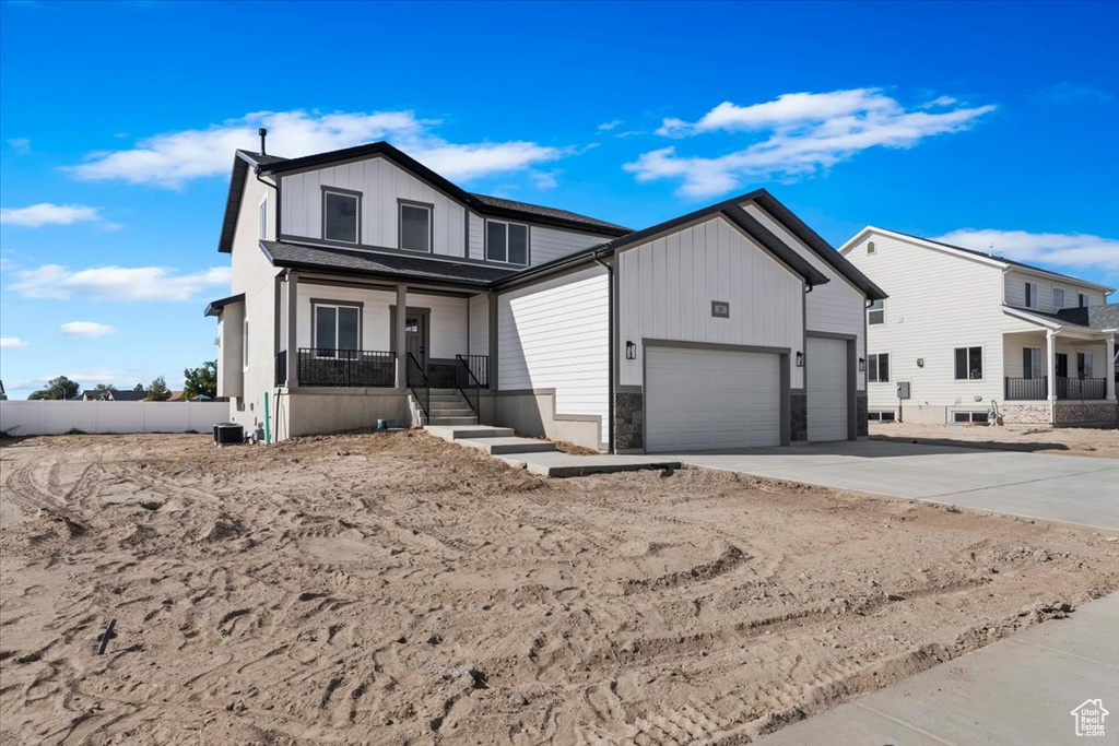 View of front of property featuring a porch and a garage