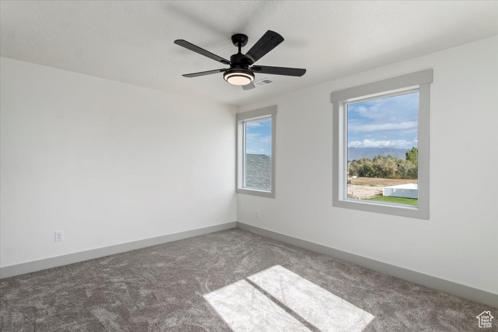 Spare room with carpet flooring and ceiling fan