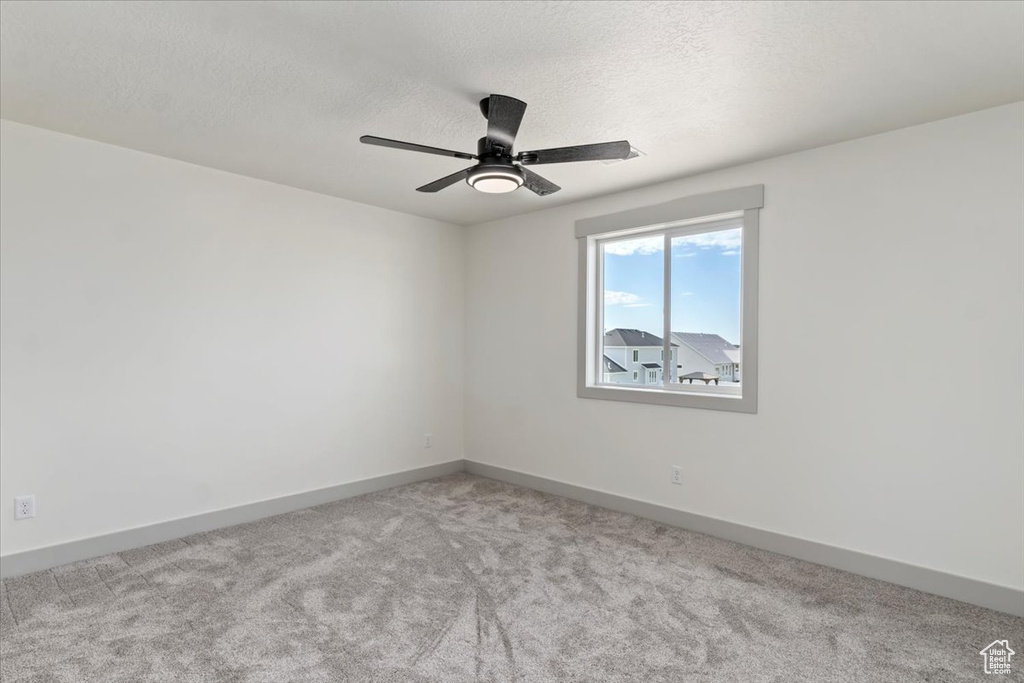 Spare room with a textured ceiling and light colored carpet