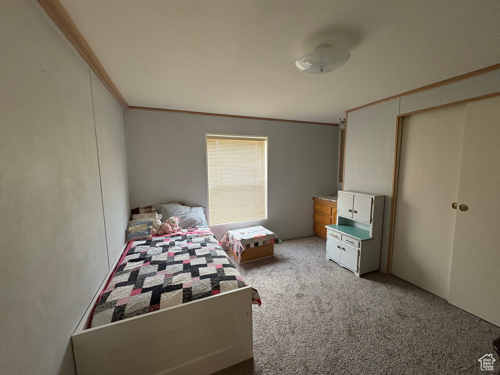 Bedroom featuring ornamental molding and light carpet