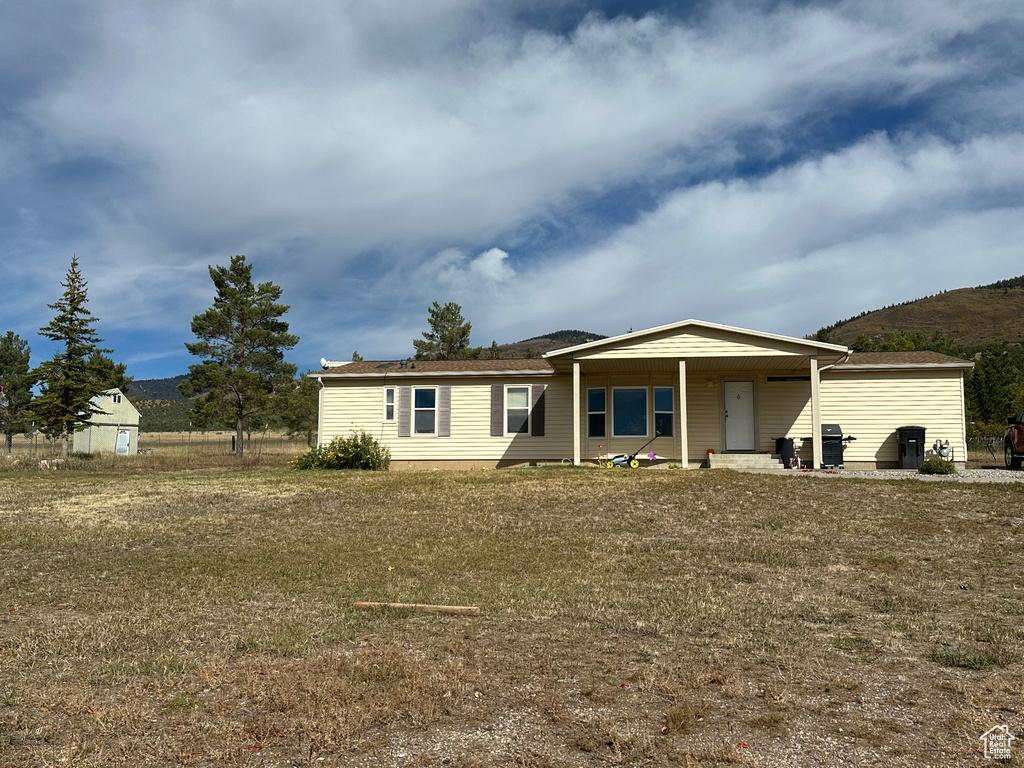 View of front facade with a front lawn and a storage shed