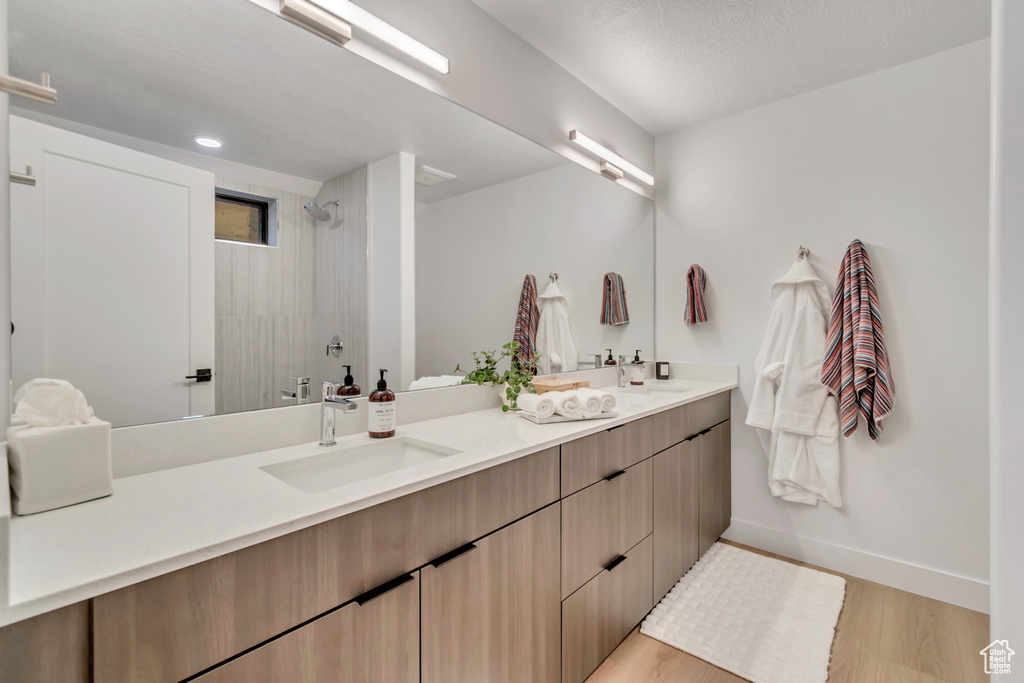 Bathroom featuring hardwood / wood-style floors, vanity, and a shower