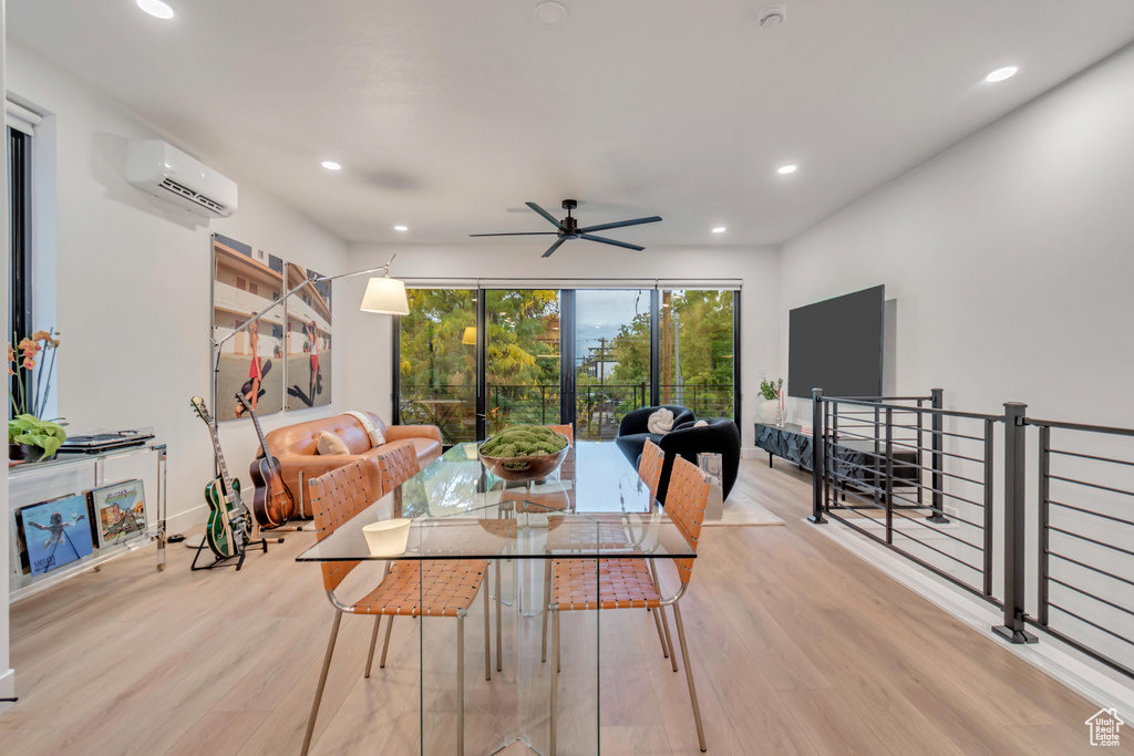 Dining area with a wall mounted air conditioner, light wood-type flooring, and ceiling fan