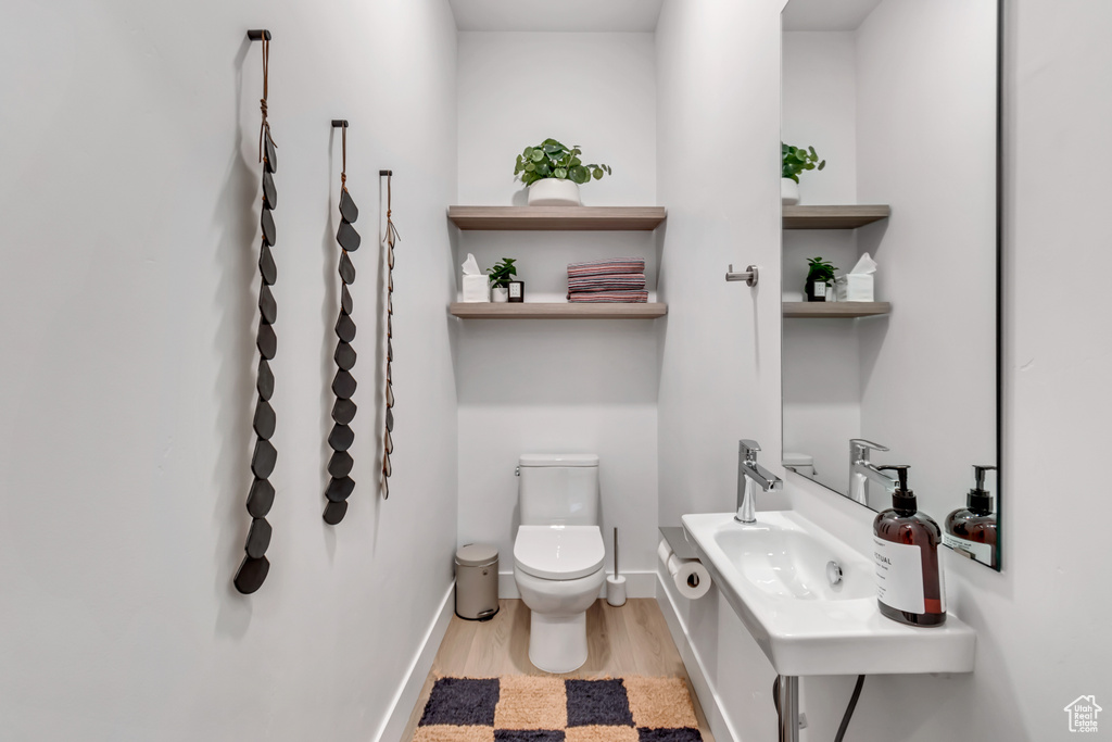 Bathroom with sink, wood-type flooring, and toilet