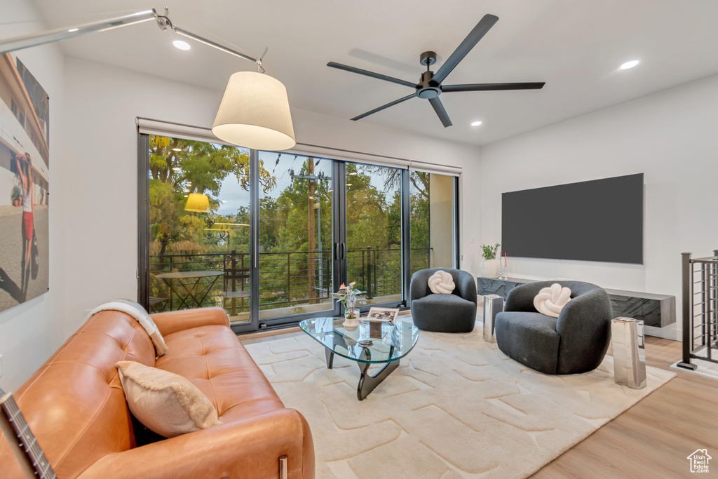 Living room with light wood-type flooring and ceiling fan